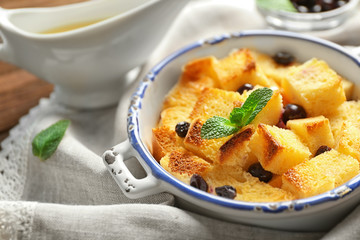 Bowl with delicious bread pudding on napkin