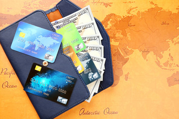 Fototapeta na wymiar Credit cards with money in wallet on world map background
