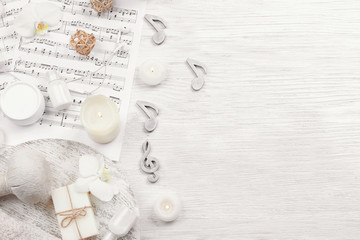 Fototapeta na wymiar Beautiful composition of spa accessories and musical notes on white wooden background