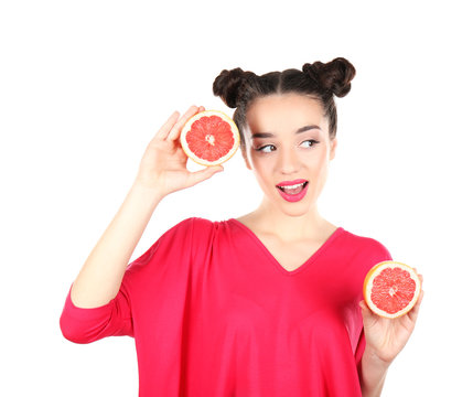 Beautiful young woman with grapefruit halves on white background