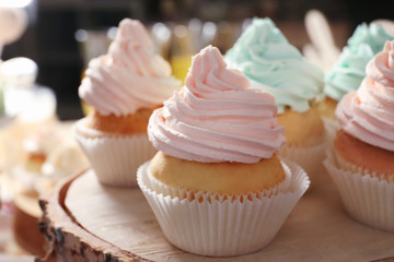 Wooden stand with tasty cupcakes, closeup