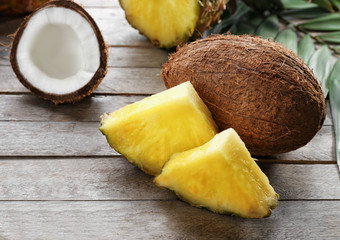 Fresh pineapple slices and coconut on wooden background