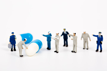 miniature people with drug capsule