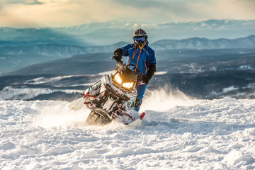 Rider on the snowmobile in the mountains. active drive - obrazy, fototapety, plakaty