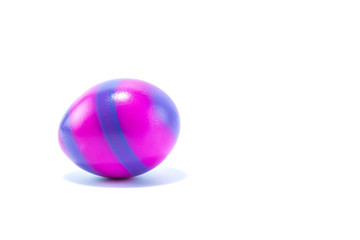 Easter egg hand painted in home - dark pink rosa with blue stripes, isolated in white background