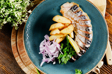 Smoked mackerel with potato slices, onions and greens