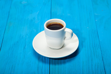 Coffee cup with espresso on blue wooden background