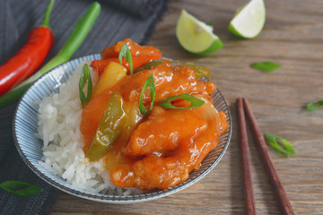 sweet and sour pork. deep fried crispy pork stir-fried with pineapple and fresh capsicum in sour and sweet sauce on rice. worldwide famous chinese cuisine.