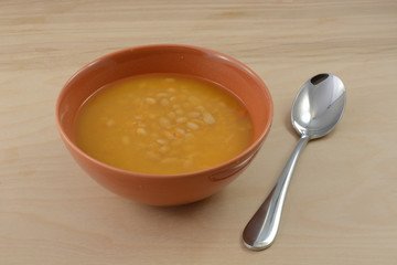 Bean soup with carrots and bacon in bowl