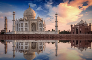 Fototapeta premium Taj Mahal with a scenic sunset view on the banks of river Yamuna. Taj Mahal is a white marble mausoleum designated as a UNESCO World heritage site at Agra, India.