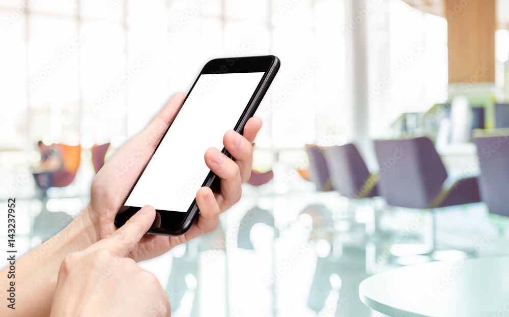 Aufkleber Hand click mobile phone with blur bank counter background bokeh light,White screen mock up template for adding your design or your text