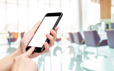 Hand click mobile phone with blur bank counter background bokeh light,White screen mock up template for adding your design or your text