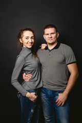 young stylish man and woman on black background