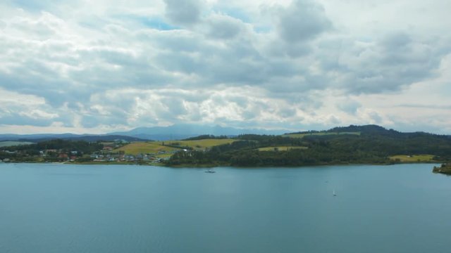 Bewitching Horizontal Panorama of Lake, Mountains, Village, Sky and Clouds