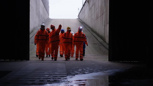  Workers at a fuel plant walking out into daylight after being underground