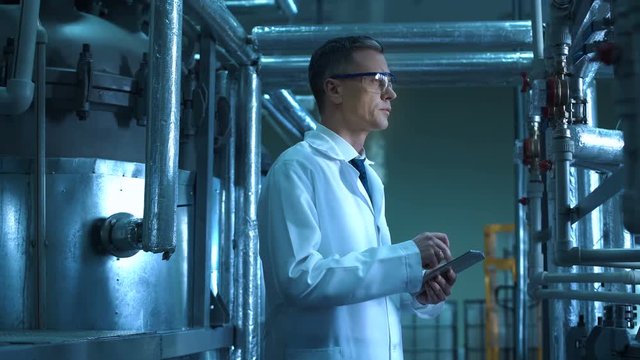 A person with a tablet providing an expertise on a plant. Horizontal indoors shot.