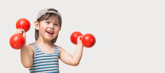 The child is engaged in physical culture with dumbbells