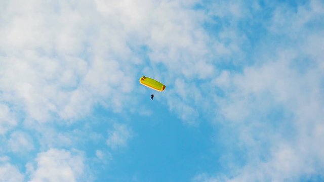 Paraglider in a blue sky with white clouds. Video.