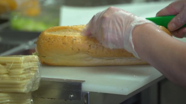 Submarine deli sandwich being made and sliced