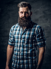 Bearded male with a tattoo on his arm dressed in a blue fleece shirt.