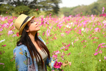 Beautiful girl in field of cosmos, so happy and relax, select focus