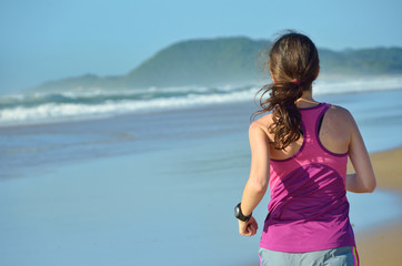 Fitness and running on beach, woman runner working out on sand near sea, healthy lifestyle and sport concept
