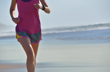 Fitness and running on beach, woman runner working out on sand near sea, healthy lifestyle and sport concept
