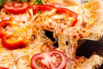 Photo of a hot pizza on wooden background. Toned image