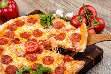 Photo of a hot pizza on wooden background. Toned image