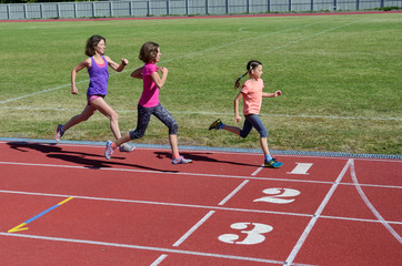 Family fitness, mother and kids running on stadium track, training and children sport healthy lifestyle concept
