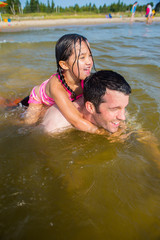 Mixed race father and daughter at the beach