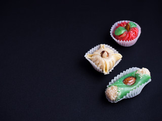 small oriental sweet cakes made of baked marzipan isolated on black background