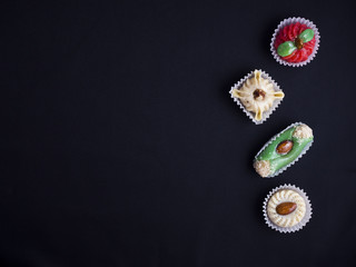 small oriental sweet cakes made of baked marzipan isolated on black background