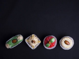 Small oriental sweet cakes made of baked marzipan isolated on black background