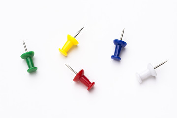Five colored push pins on white background