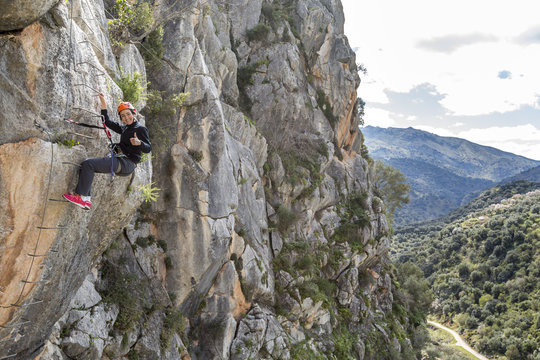 woman climbing a via ferrata