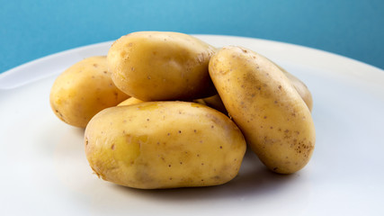 plate with potatoes on blue background.