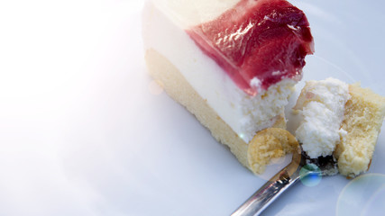 plate with piece of square cream cake and fork.