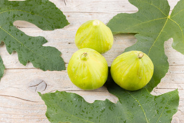 Ripe fresh green figs on wooden background