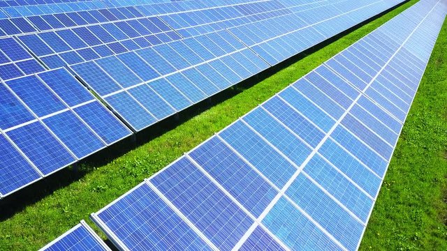 solar panels field aerial view flying low over green renewable energy plant