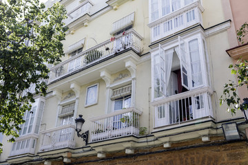Detail of balconies and large windows on the time of the nineteenth century, Narrow street with traditional architecture in Cadiz, Andalusia, southern Spain