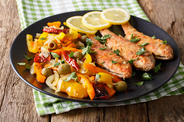 Roasted red mullet with garnish of stewed vegetables close-up. horizontal