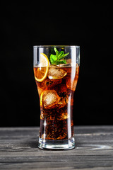 Beautiful glass with cola with lemon, ice and mint