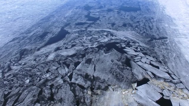 4K. Floating cracked ice and sludge on river. Aerial.
