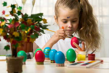 Fototapeta na wymiar Caucasian girl kid draw eggs before easter holiday