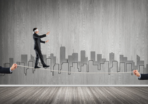 Business concept of risk support and assistance with man balancing on rope
