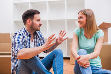 Young couple is moving in their new home. It's time for unpacking.