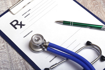 Closeup of a pils, stethoscope, pen on an rx prescription.