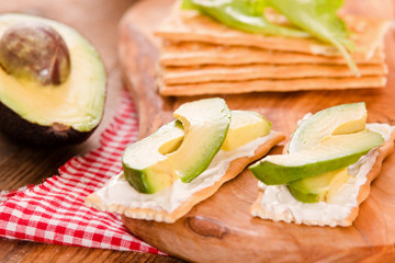 Crackers with ham and avocado. 