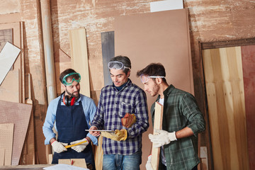 Schreiner mit Tablet Computer in Werkstatt